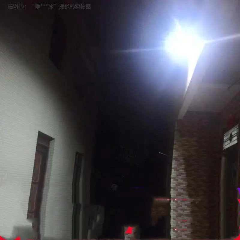 Black solar-powered outdoor LED flood light with remote control on a garden wall.