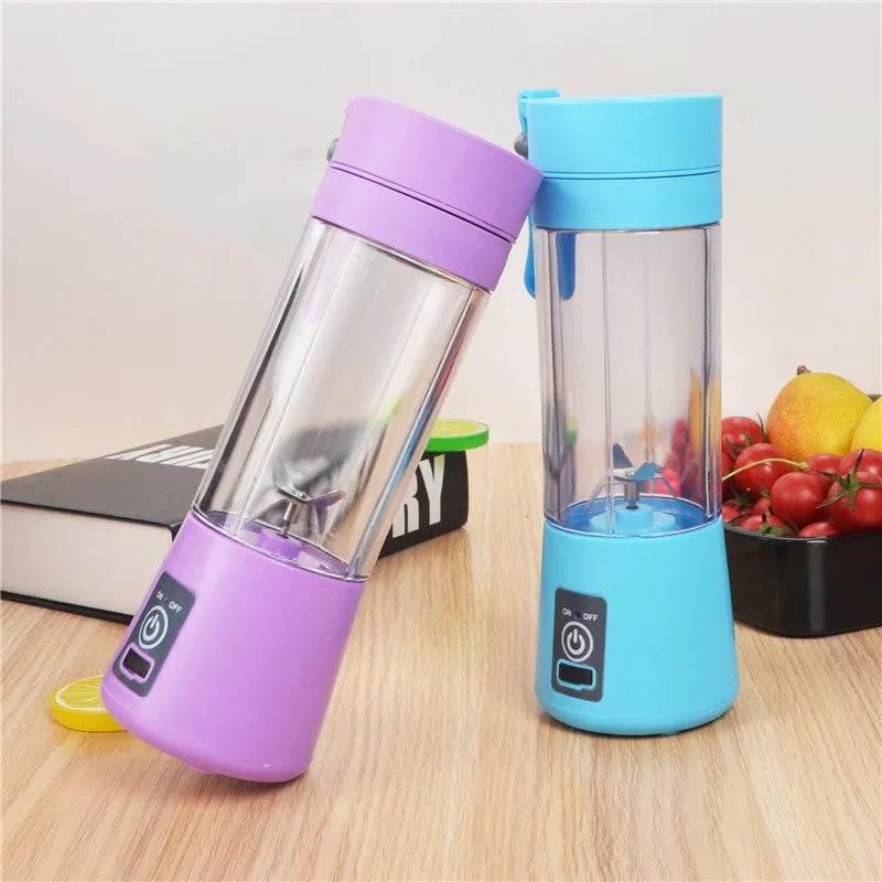 Pink mini USB electric fruit juicer with carrying rope on a kitchen countertop.