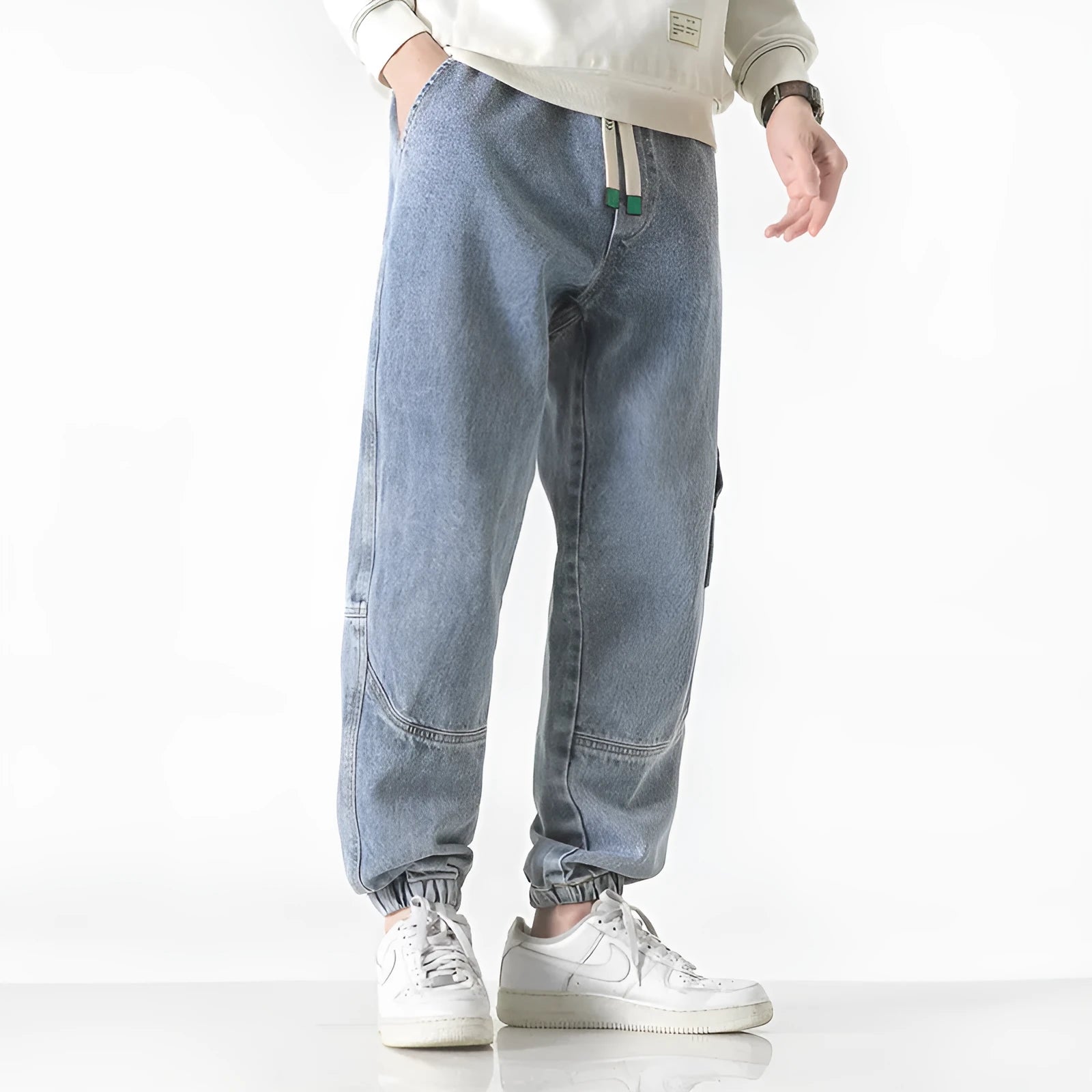 Men's loose-fit tapered cotton trousers in black showing mid-waist design and tapered leg cut