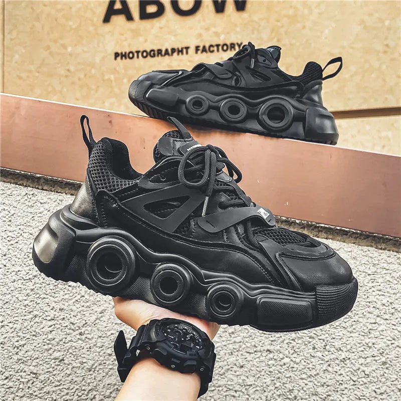 Men's black mesh sneakers with thick rubber sole, round toe, lace-up front, and abstract pattern