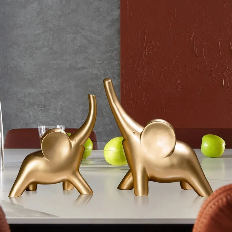 Modern resin elephant ornament in rose gold colour with raised trunk on display surface