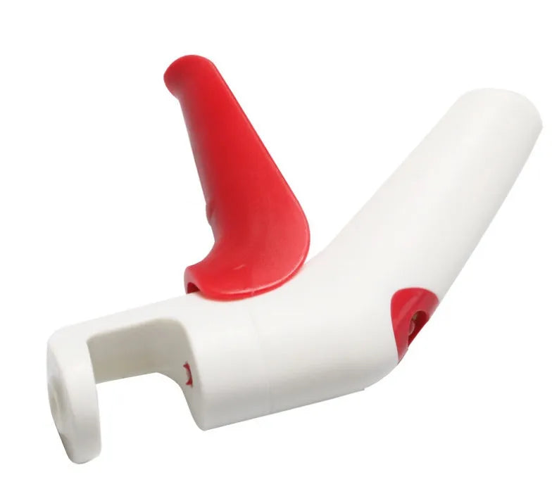 Red and white stainless steel manual cherry kernel remover pitter on a clean surface