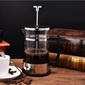 Manual pour-over coffee maker with glass carafe and stainless steel filter, 350ml capacity.
