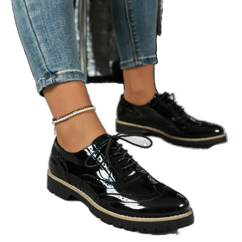Women's black oxford shoes with wedge heel and sequin detailing, showing round toe and middle mouth cut