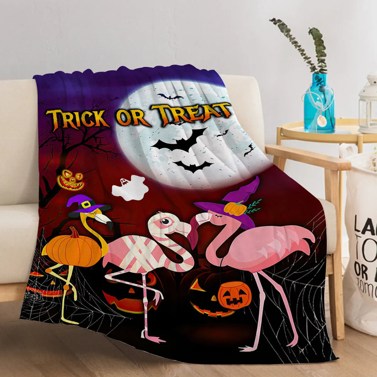 Purple flannel Halloween flamingo printed blanket on a sofa, size 130x150cm