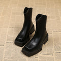 Black women's platform Martin boots with a square toe, high heel, and back zipper on a neutral background.