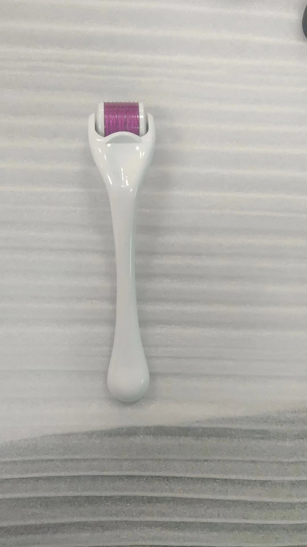 540 micro needle derma roller with black handle and purple wheel, showing adjustable needle sizes.