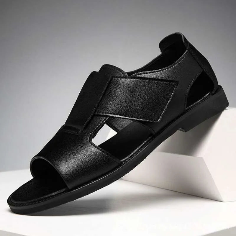 Men's black and brown leather open-toe Roman sandals with a rubber sole on a plain background.