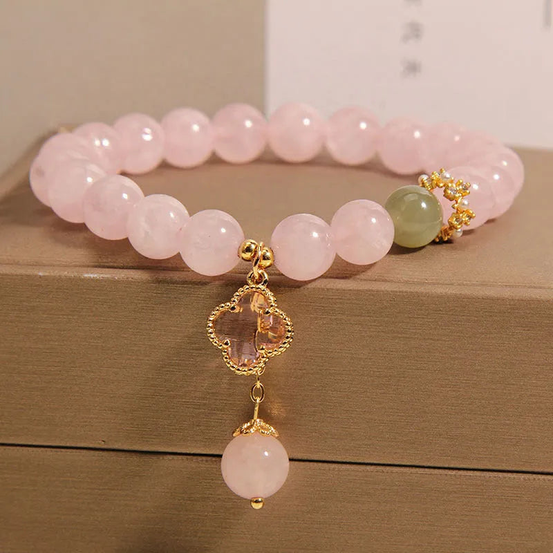 Pink crystal bracelet for women with a four-leaf clover pendant and sparkling rhinestones.