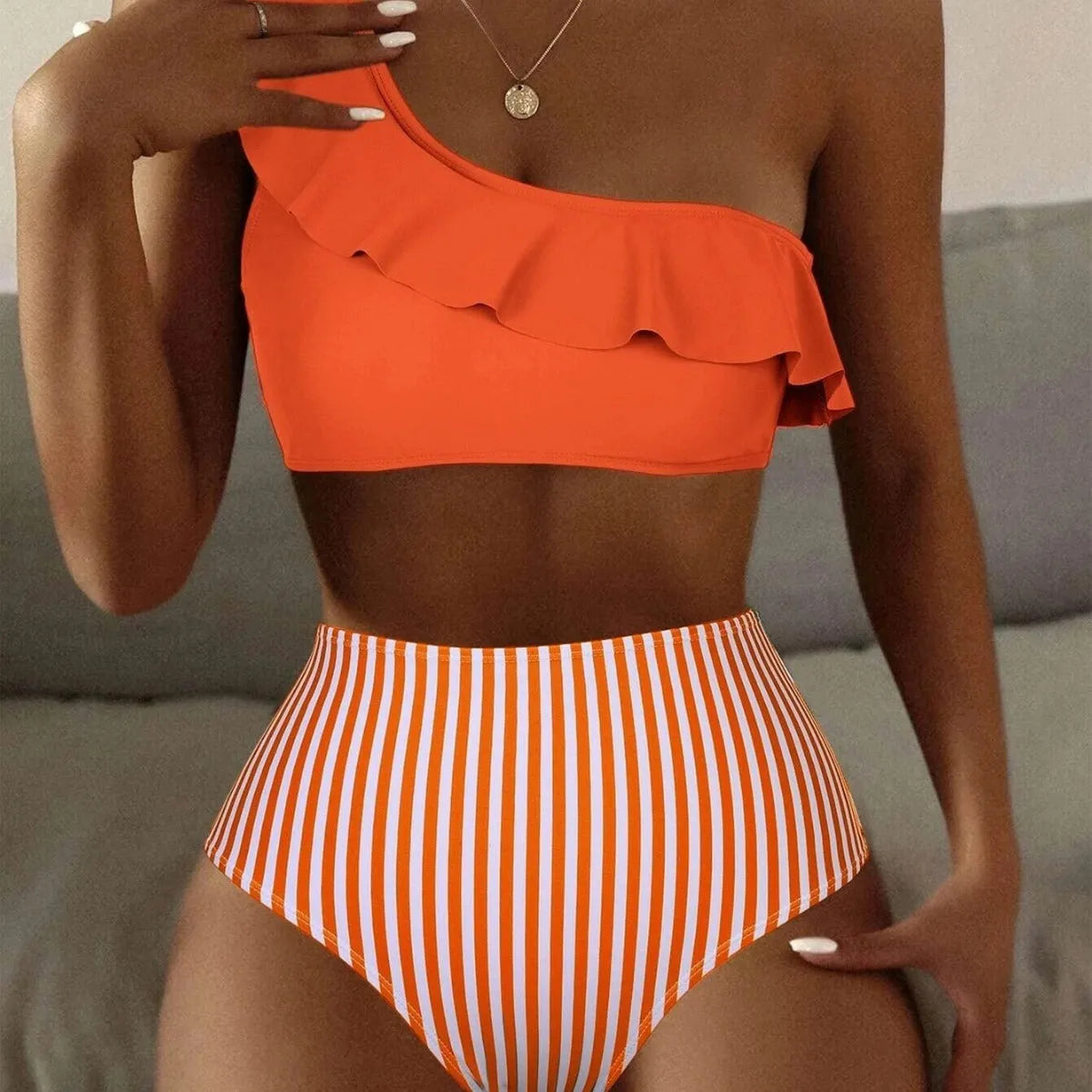 Women's striped solid colour split bikini swimsuit on a mannequin, showing the sleeveless top and briefs.