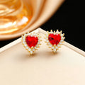 Gold red titanium steel necklace with heart and flower gemstone pendant, matching earrings, and ring on a grey background.
