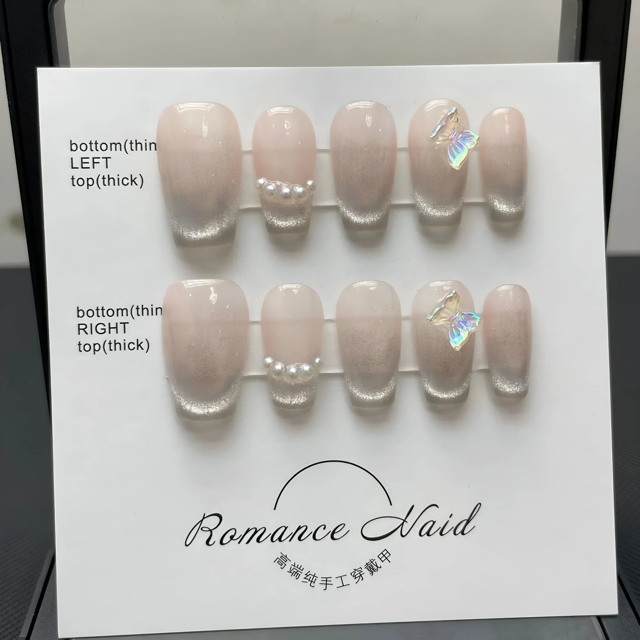 Women's short blush-coloured press-on artificial nails laid out in sizes XS, S, M, and L.