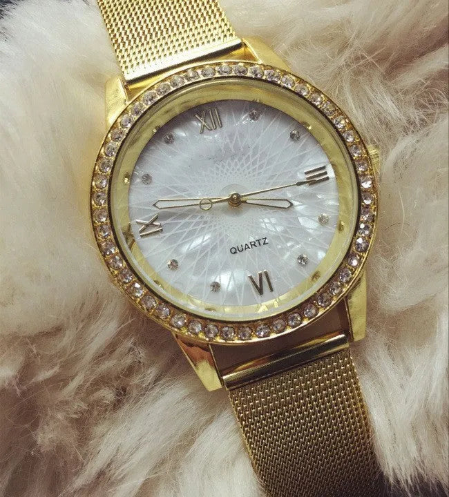 Golden mesh strap alloy electronic watch with round dial and world time GMT functions on a plain background
