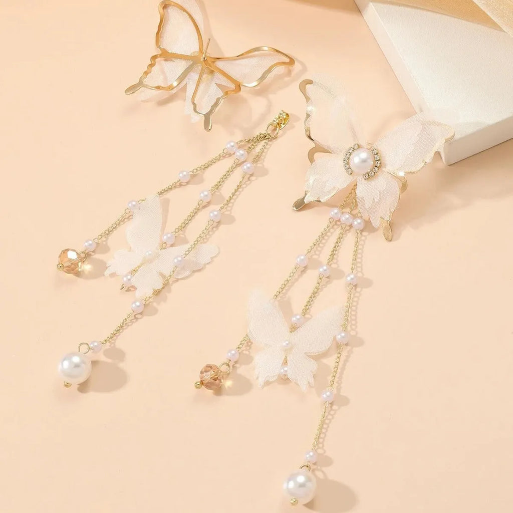 A pair of white butterfly-shaped earrings with lace, pearl, rhinestone and tassel details on a copper alloy base.