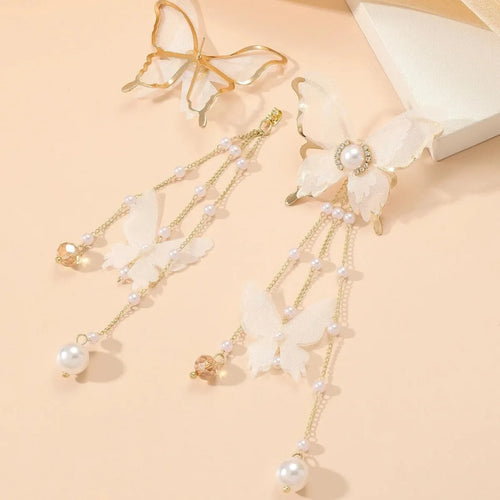 A pair of white butterfly-shaped earrings with lace, pearl, rhinestone and tassel details on a copper alloy base.