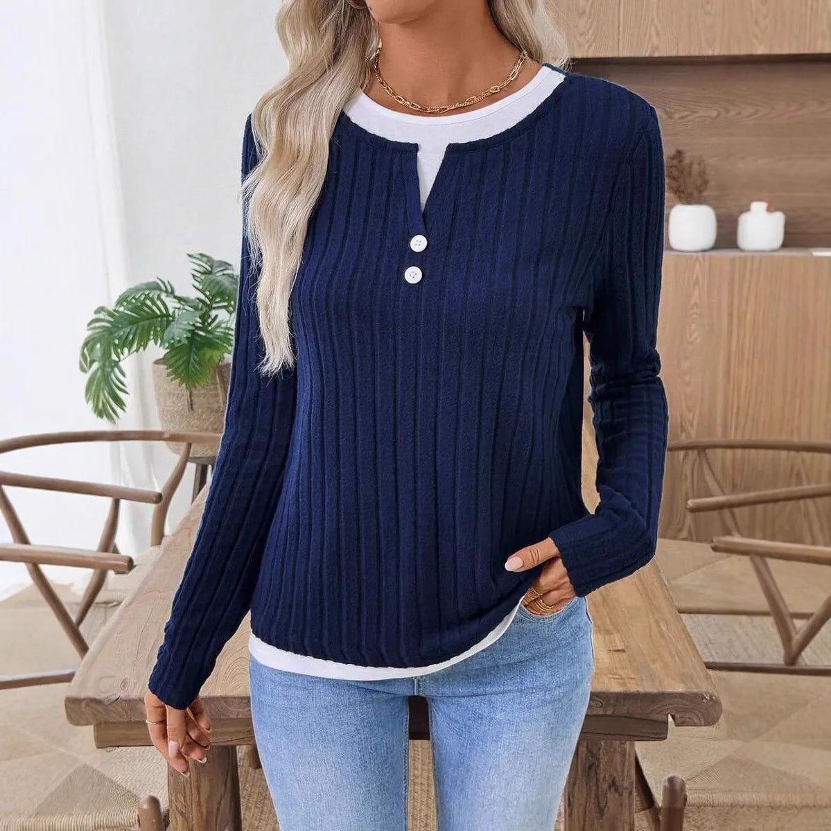 Women's black two-piece style pullover sweater with round neck and button detail on long sleeves.