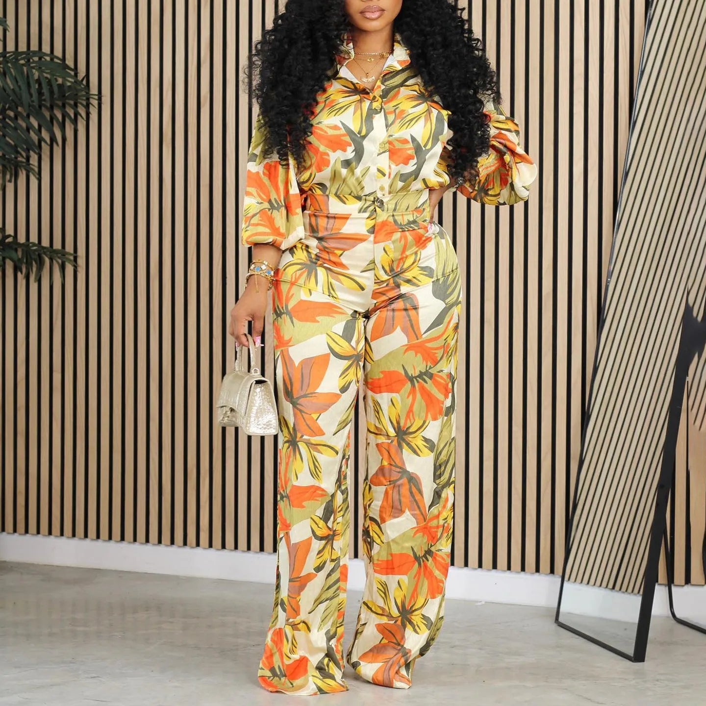 Red printed women's two-piece suit with long sleeve shirt and wide leg trousers on hanger