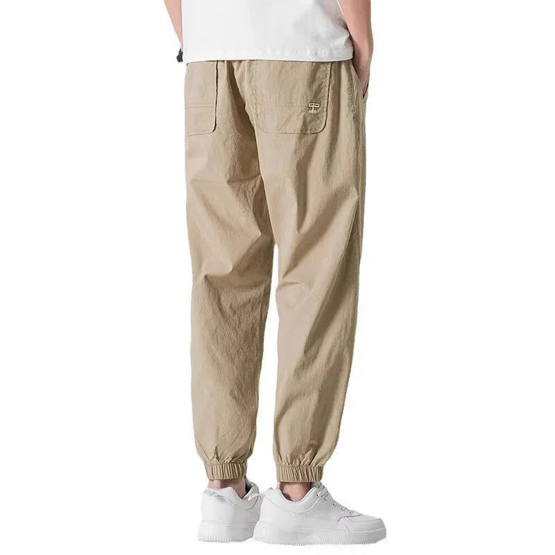 Men's loose cuffed cargo pants in black polyester fabric with cuffed hem and relaxed fit