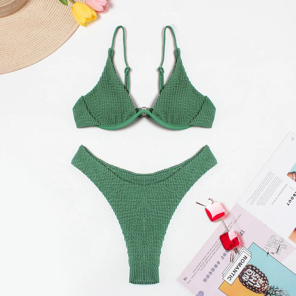 Women's solid green bikini suit with ruffle detailing and split-front design on mannequin