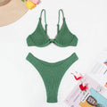 Women's solid green bikini suit with ruffle detailing and split-front design on mannequin