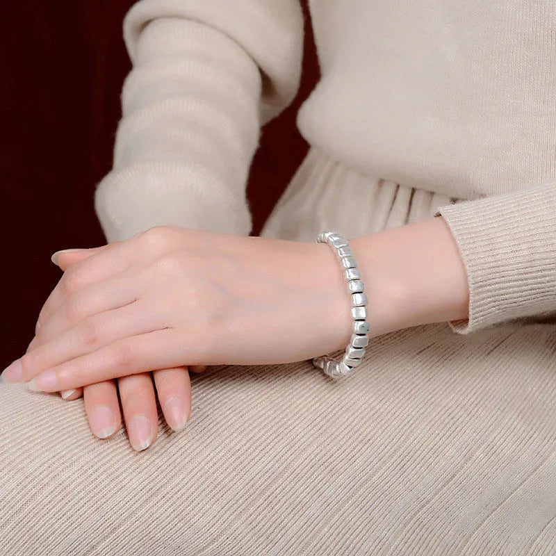 Handmade women's bracelet with irregular square design in wood and silver materials on elastic band