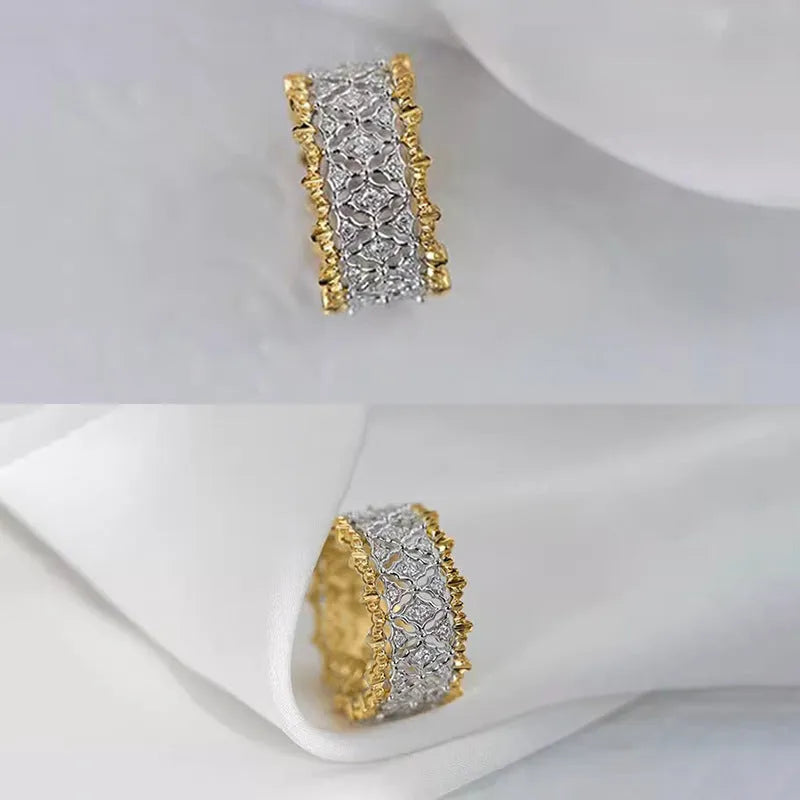 Geometric two-tone gold zircon ring on a plain background showing its round centrepiece and band detail