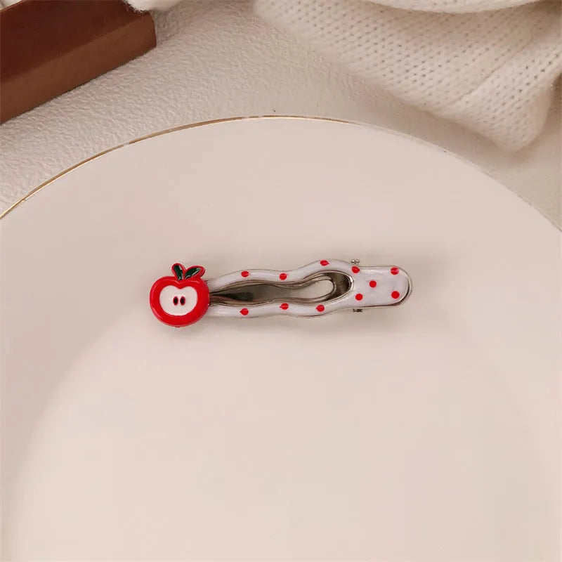 Red love heart-shaped plastic hair clip with retro dots and a willow leaf silhouette on a white background.