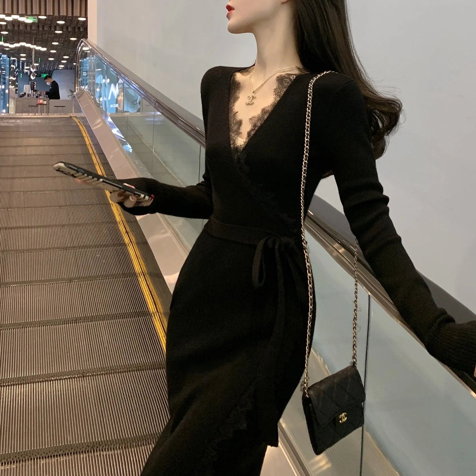 Black slim fit wool skirt dress with a princess A-line silhouette on a hanger.
