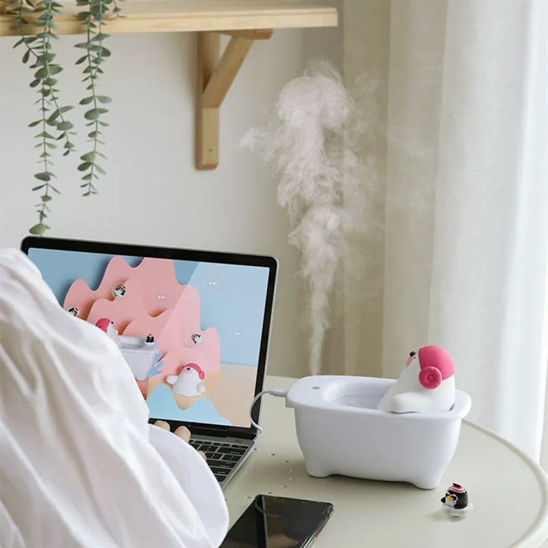 White plastic USB desktop air humidifier and essential oil diffuser on a wooden table.