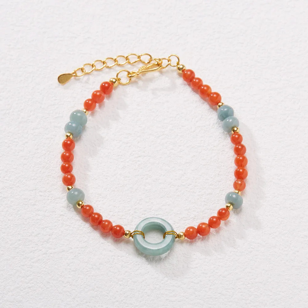 A woman's adjustable South Red Agate bracelet with 4mm beads and a safety buckle on a wrist.