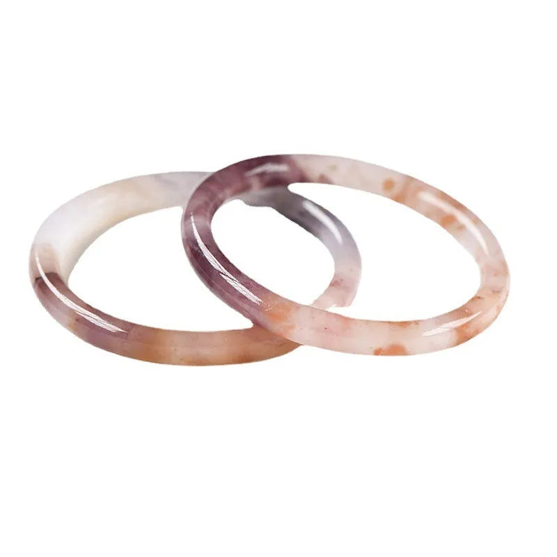 Violet jade bracelet with polished beads shown in flat bar and round bar styles on a wrist.