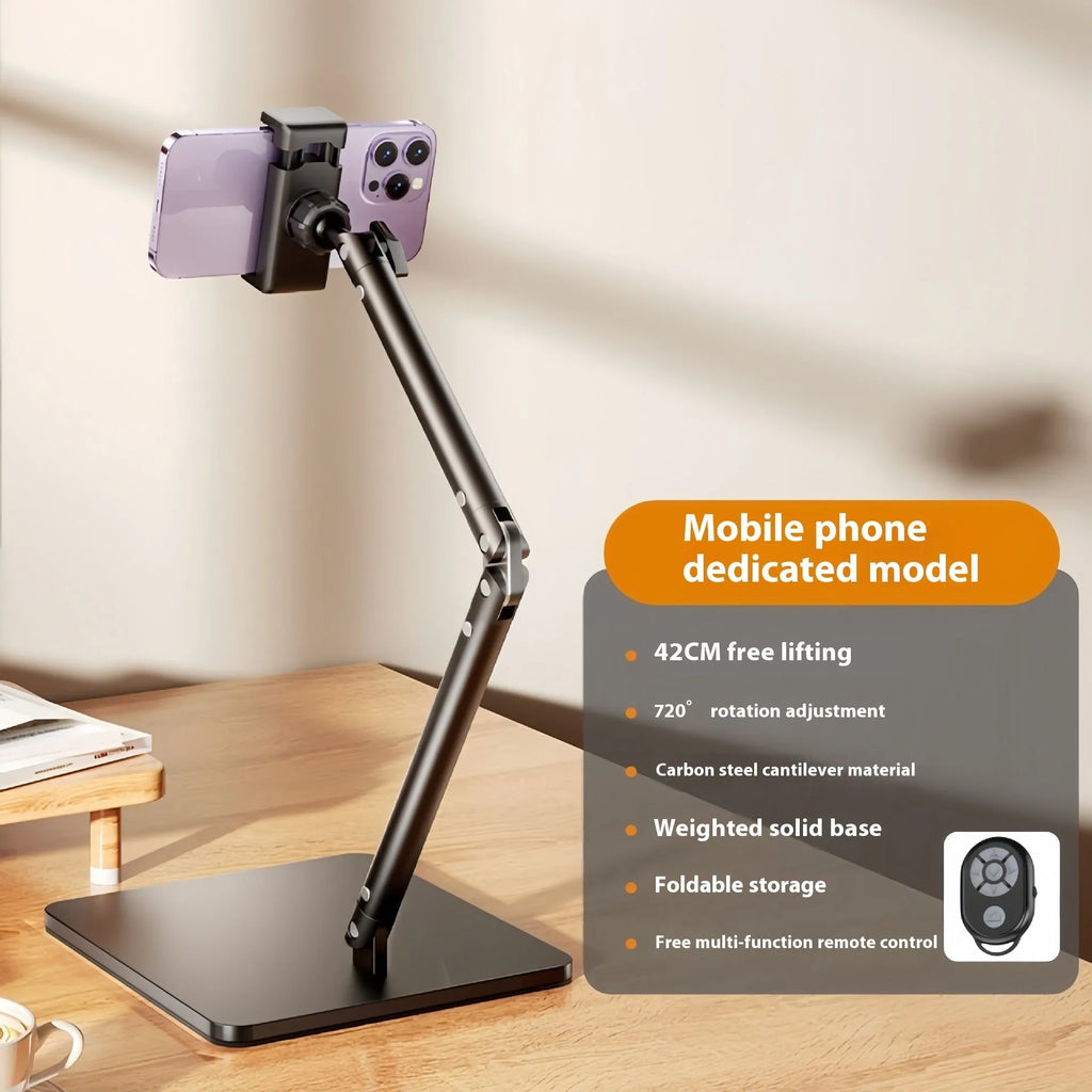 Silver alloy desktop phone and tablet bracket with double adjustable arms and a remote control on a wooden desk.