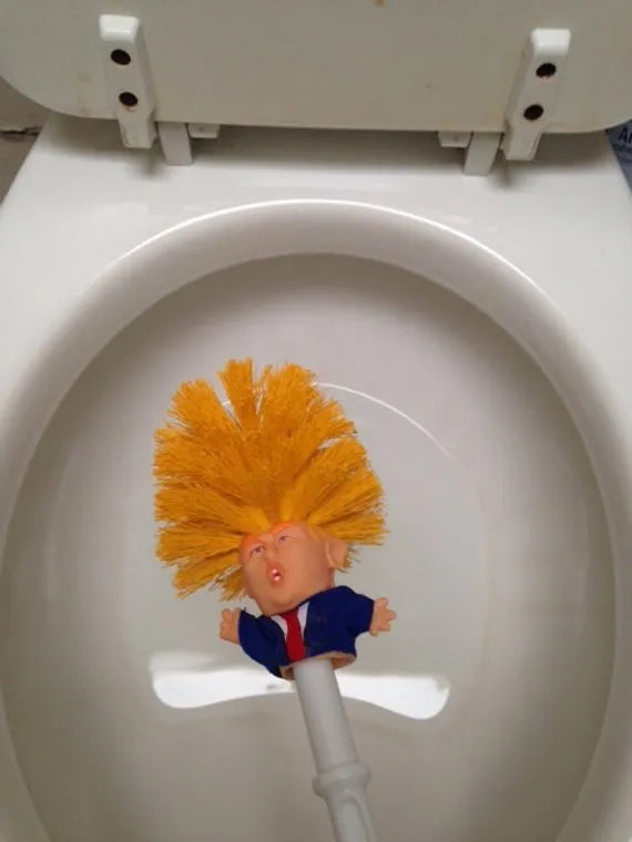 Yellow plastic Donald Trump toilet brush with hanging slot on handle.