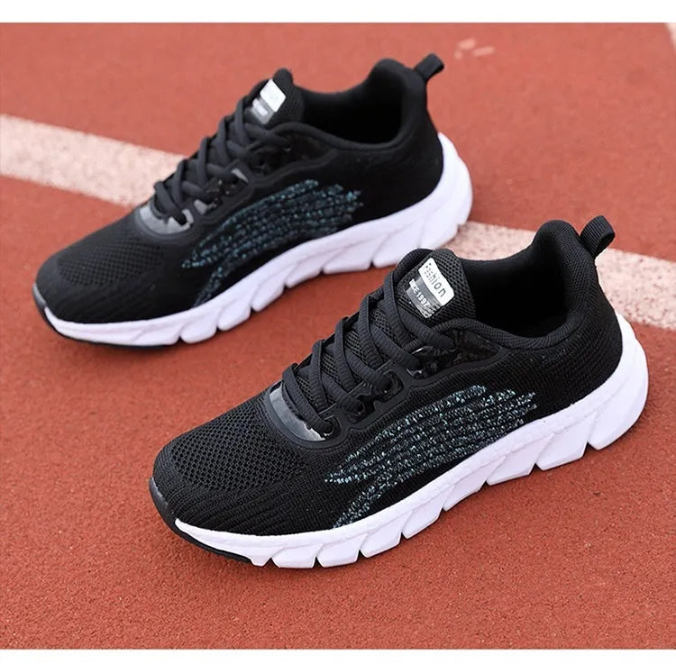 Women's low-top platform running sneakers in black and white colours with round toe and cross strap design
