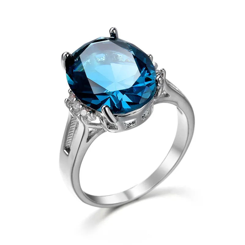 Geometric copper ring with blue black electroplated finish and an elliptical zircon centrepiece.