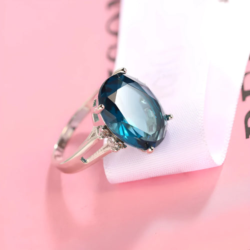 Geometric copper ring with blue black electroplated finish and an elliptical zircon centrepiece.