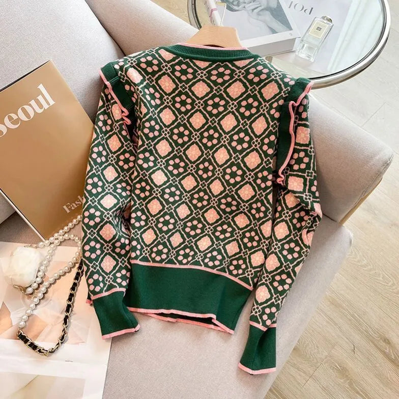 Green printed knit sweater on hanger showing loose fit and graphic pattern detail
