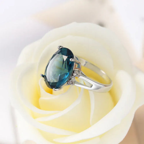 Geometric copper ring with blue black electroplated finish and an elliptical zircon centrepiece.
