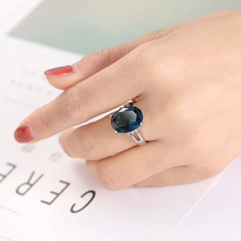 Geometric copper ring with blue black electroplated finish and an elliptical zircon centrepiece.