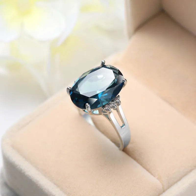 Geometric copper ring with blue black electroplated finish and an elliptical zircon centrepiece.
