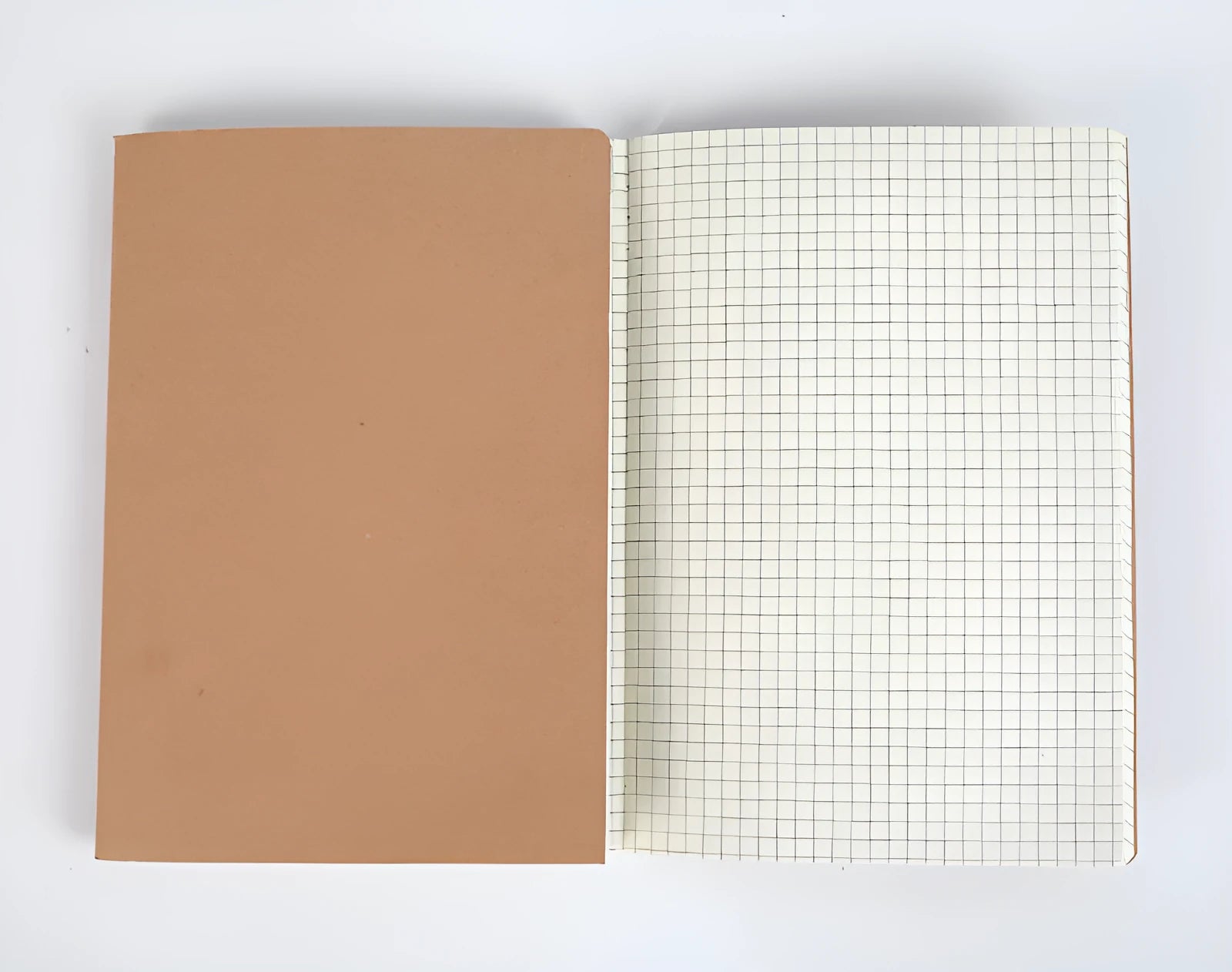 Softcover thread-bound notebook open on a table, showing flat-lay binding and lined paper.