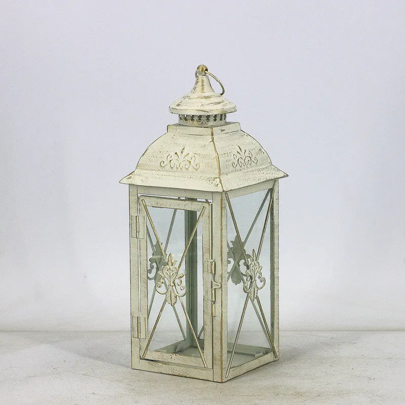 European wrought iron storm lantern with tempered glass in black or white gold finish, shown in small, medium, and large sizes.