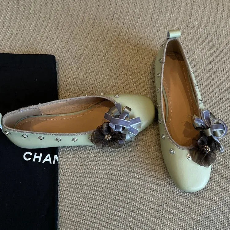 Women's silver Mary Jane flat shoes with flower rivets and a buckle strap on a sheepskin upper.