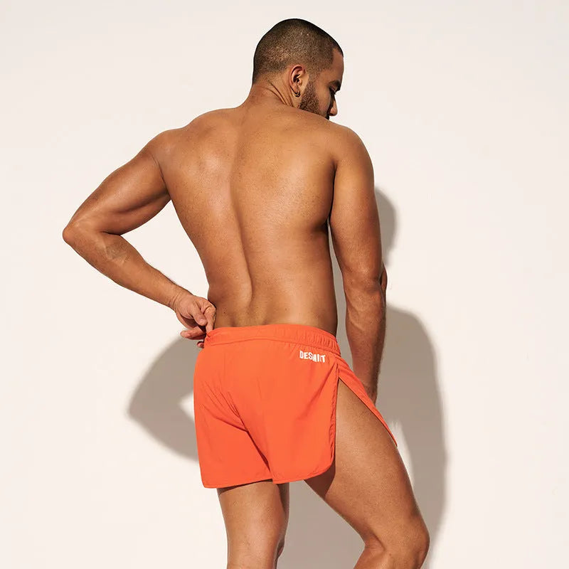 Men's loose fit elastic waist shorts in orange, green, or black for beach and surfing