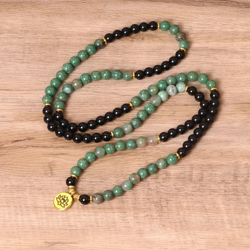Green and black elastic beaded alloy bracelet on a wrist, showing its natural style and length.