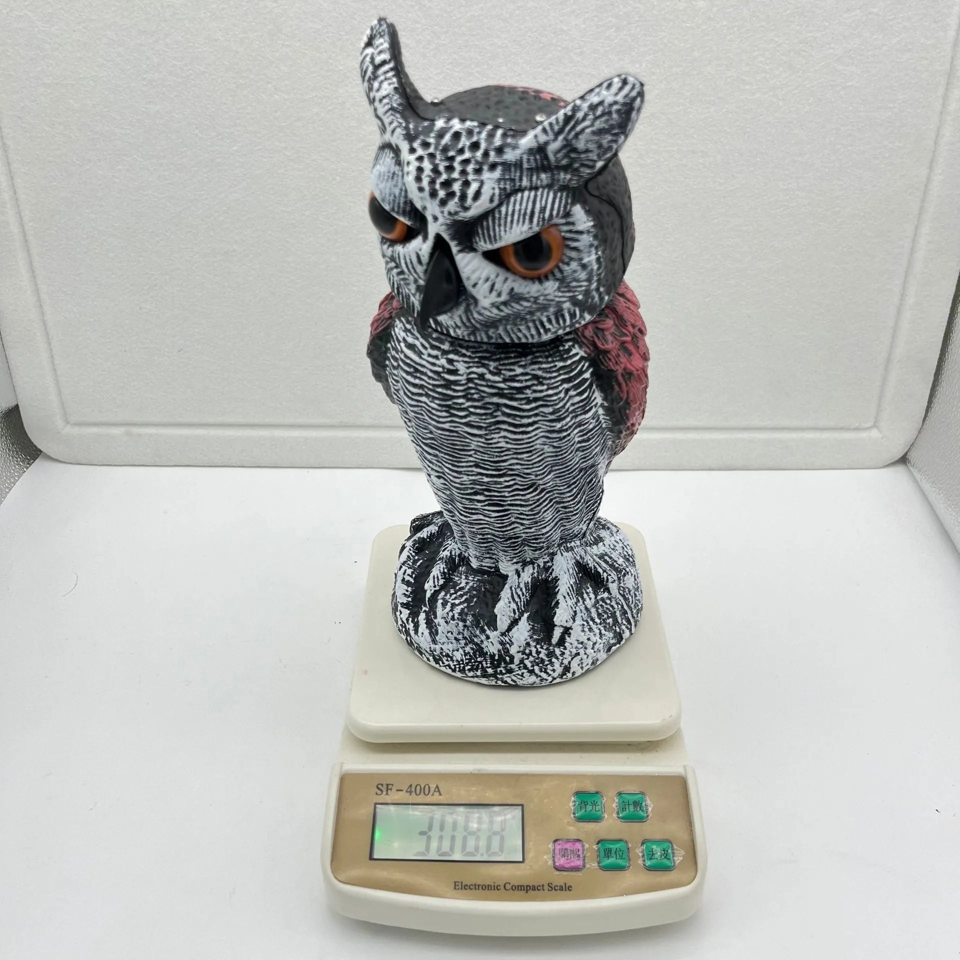 Artificial owl bird deterrent ornament with shaking head design in outdoor garden setting