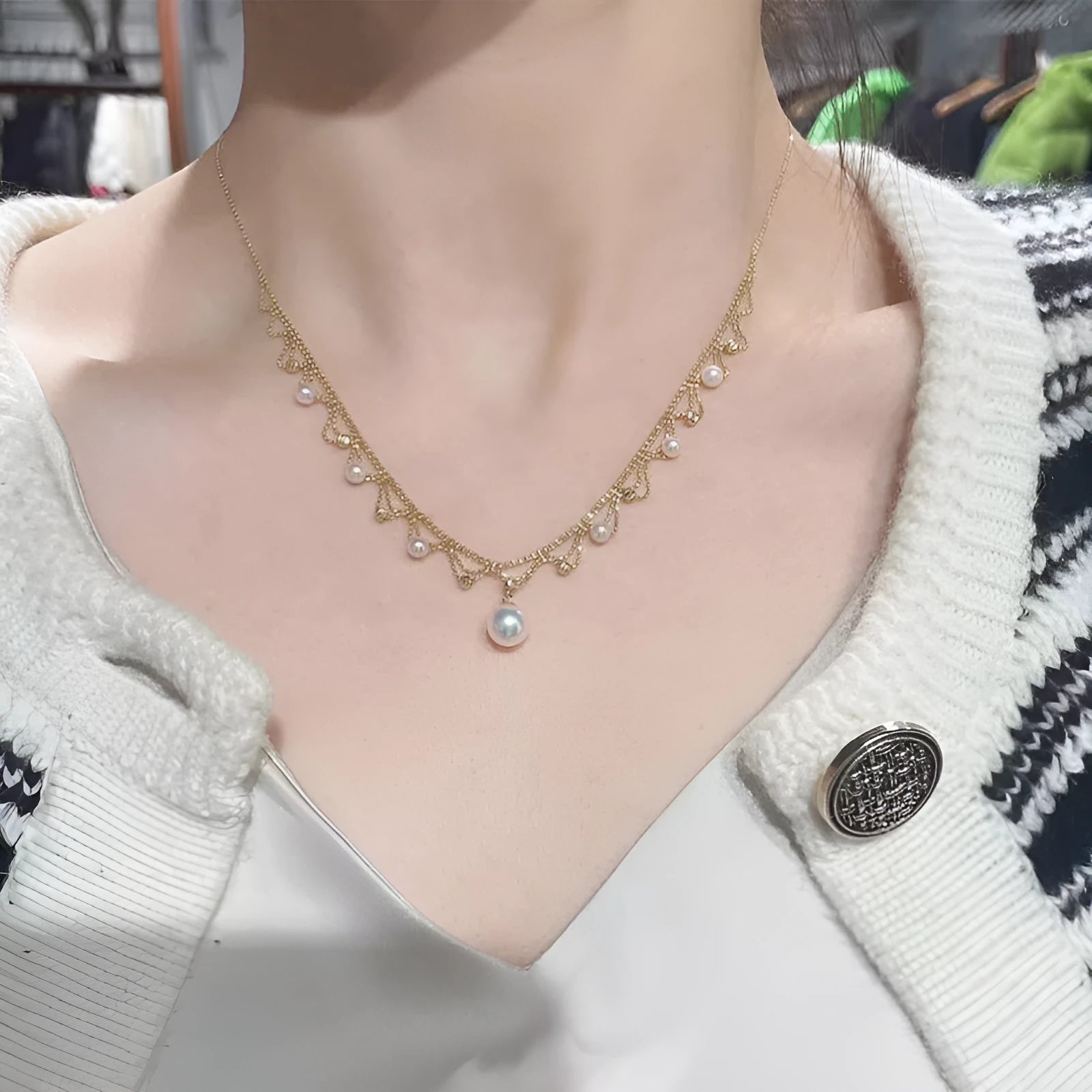 Aurora Japanese 18k gold lace pearl necklace with round sea pearl and gold finish on display