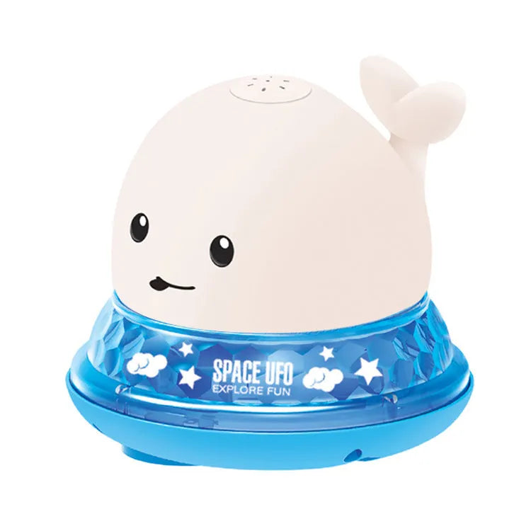 White and blue whale-shaped bath toy spraying water with LED lights on, floating in a baby bath