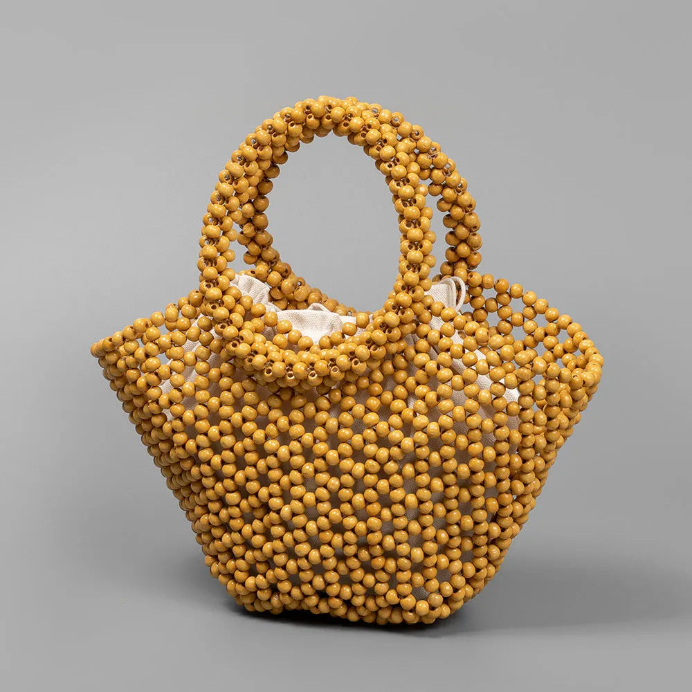 Hand-woven dumpling-shaped handbag with wooden beads in milky white colour