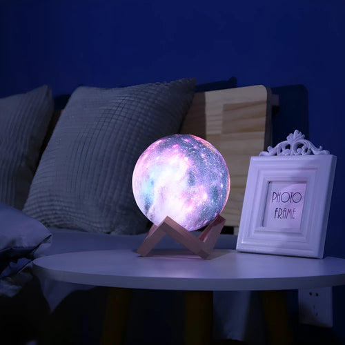 3D-printed sphere lunar night light on a base with a remote control.